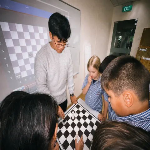 Coach guiding students at a demo board