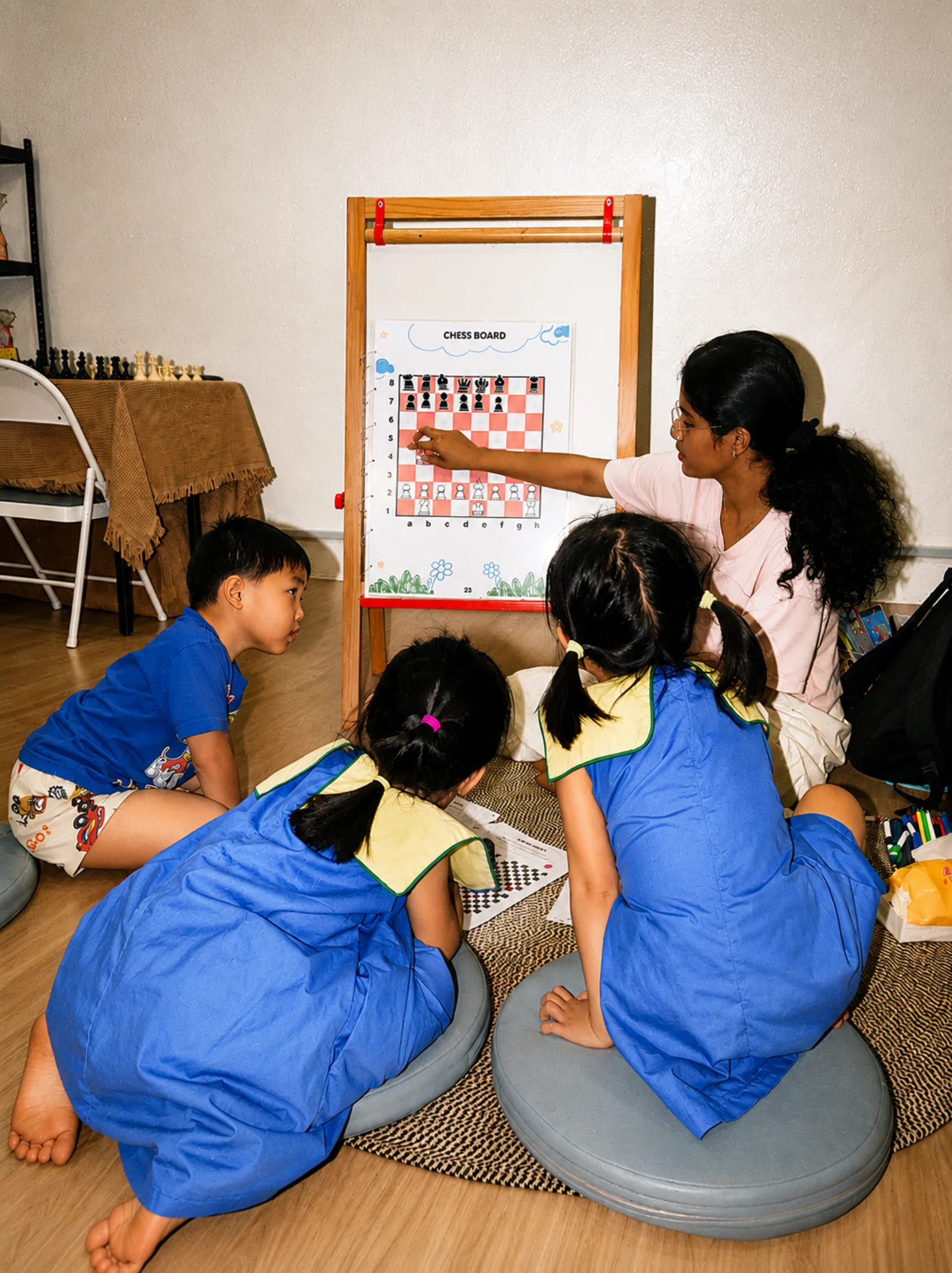 Young children learning chess with a coach