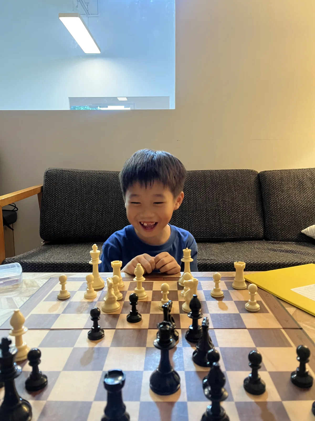 A young student smiling over a chessboard