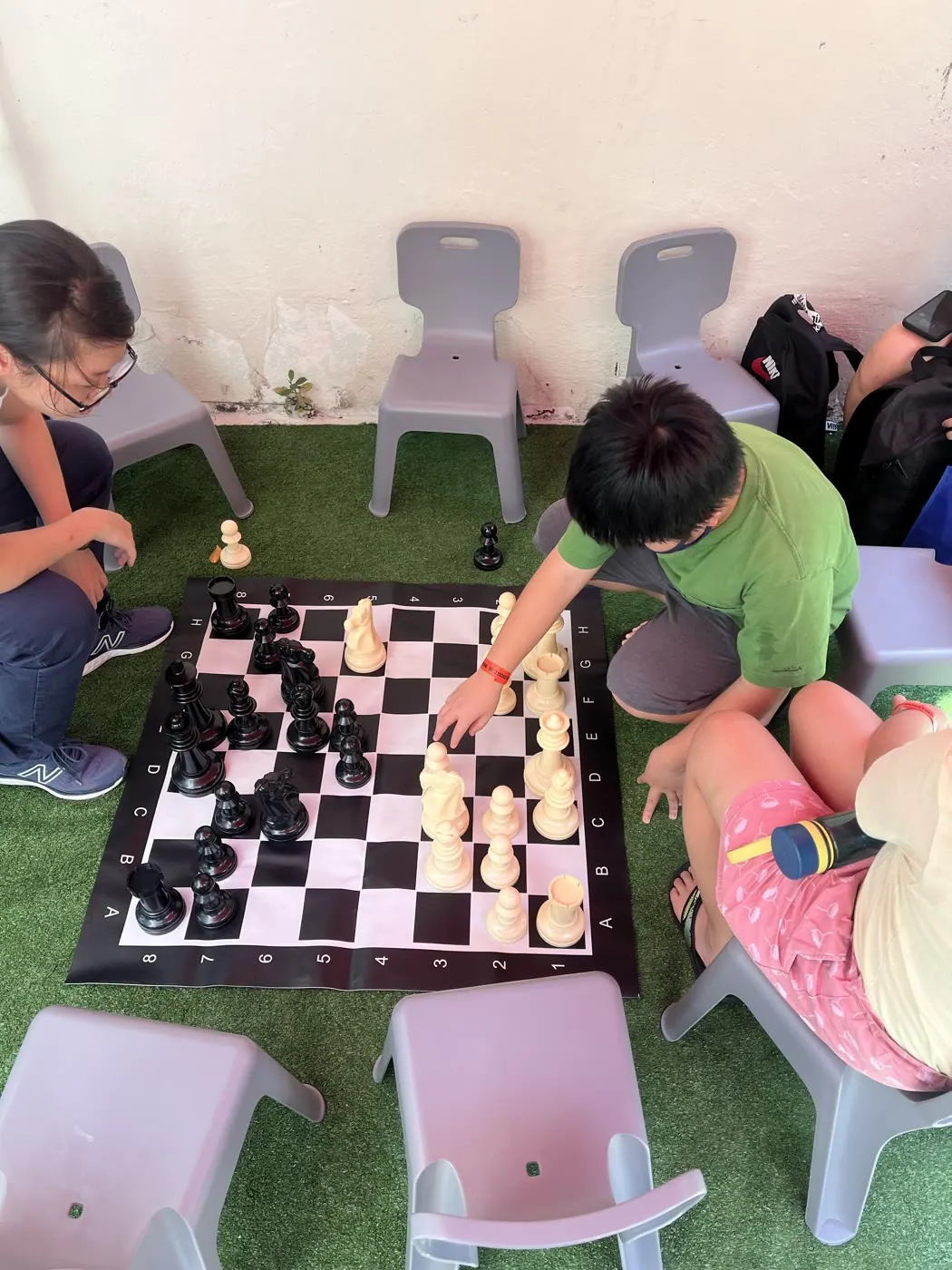 Young visitors playing a giant chess game together