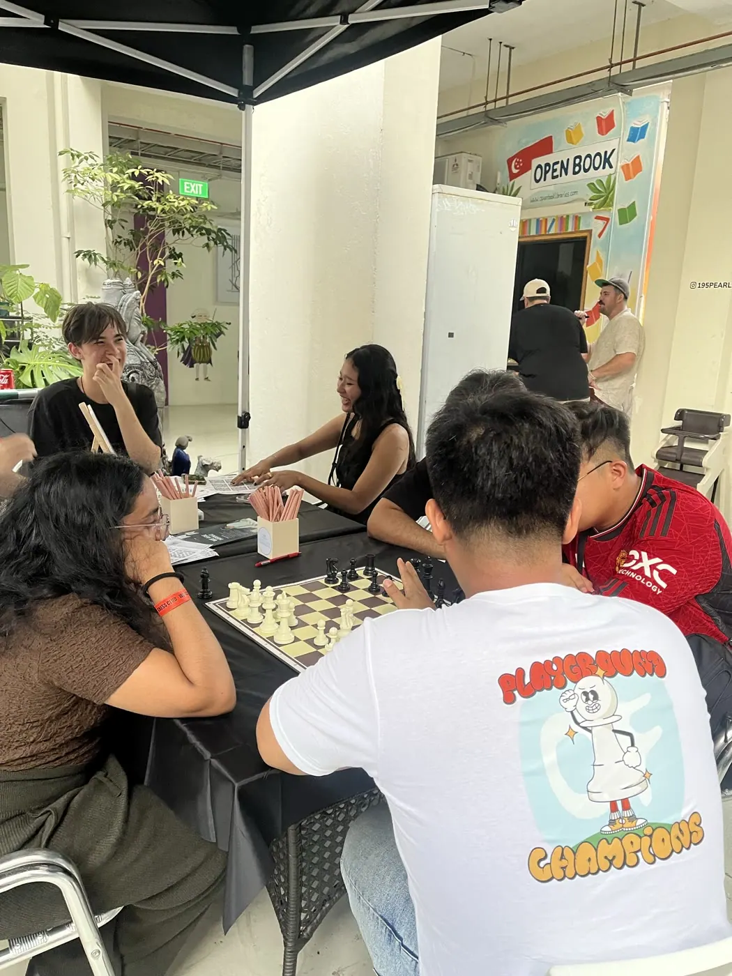 Players gathered closely around a chessboard at the event