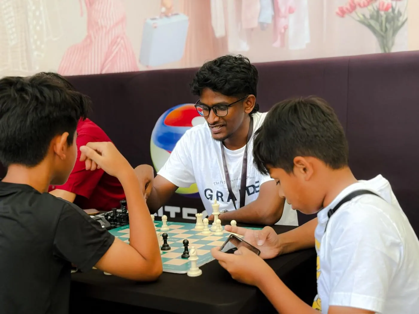 A volunteer playing chess with a young visitor at Castle for a Cause