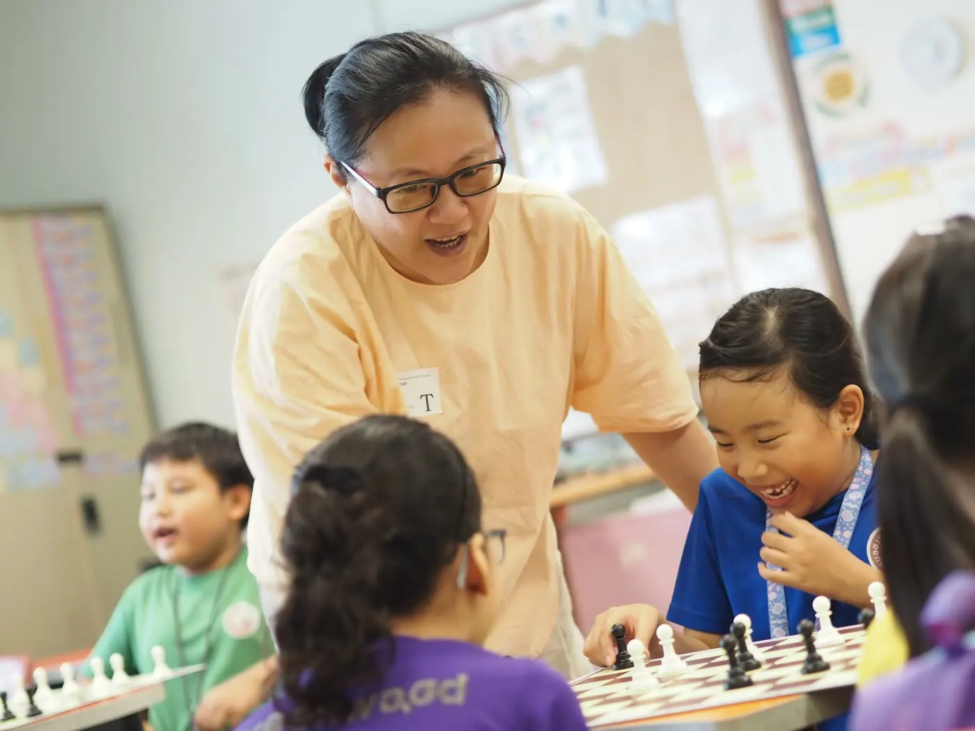 A Chess Grande contributor guiding children over a chessboard
