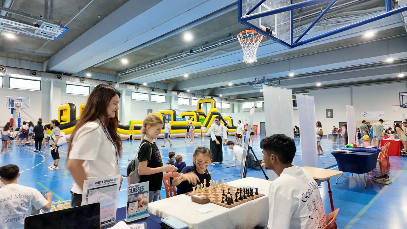 Families playing friendly games at the Chess Grande booth at Fête de l’École