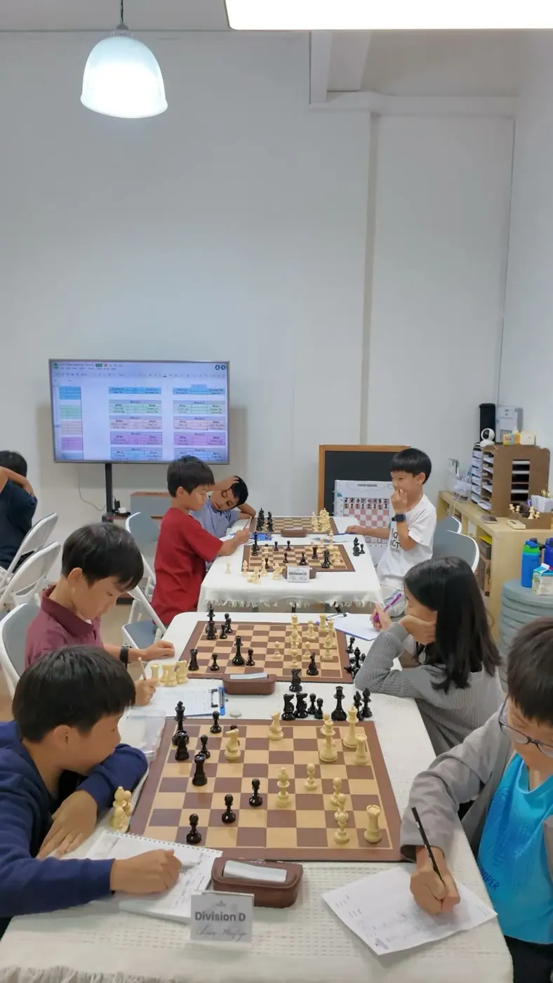 A long meetup table with several chess games in progress