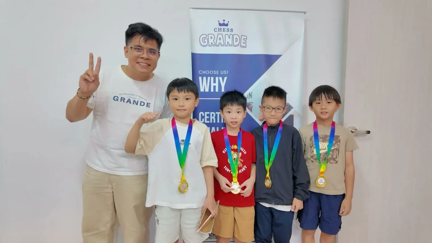 Chess Grande players and a coach celebrating with medals