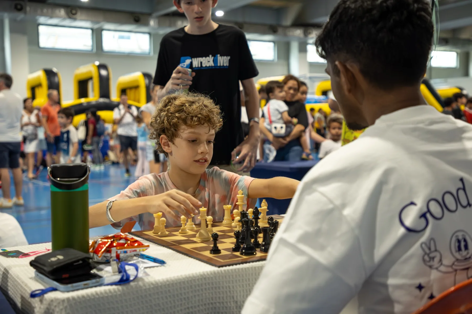 A child playing chess with a Chess Grande coach at Fête de l’École