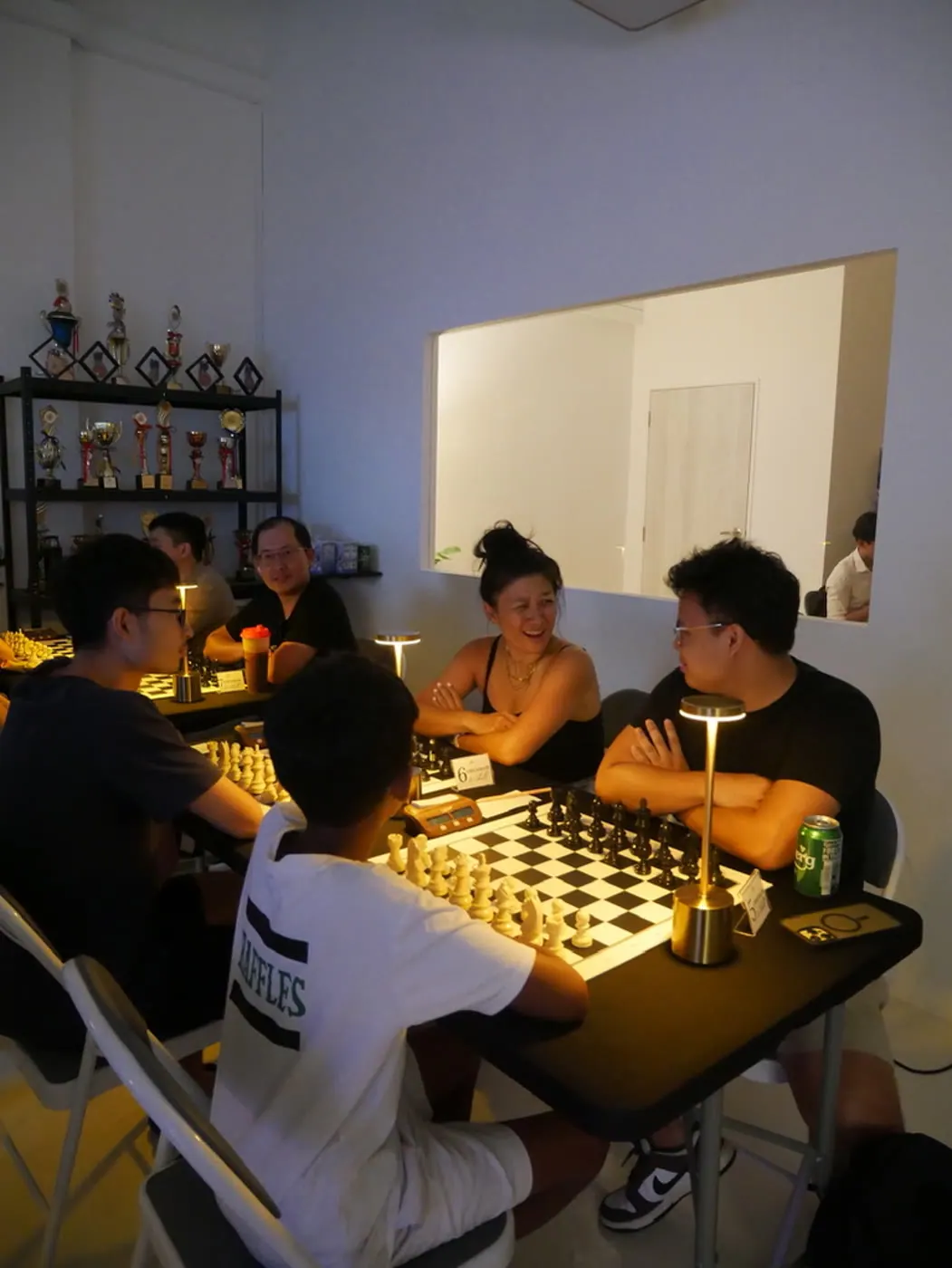 Adults socialising over chess games at Checkmate and Chill