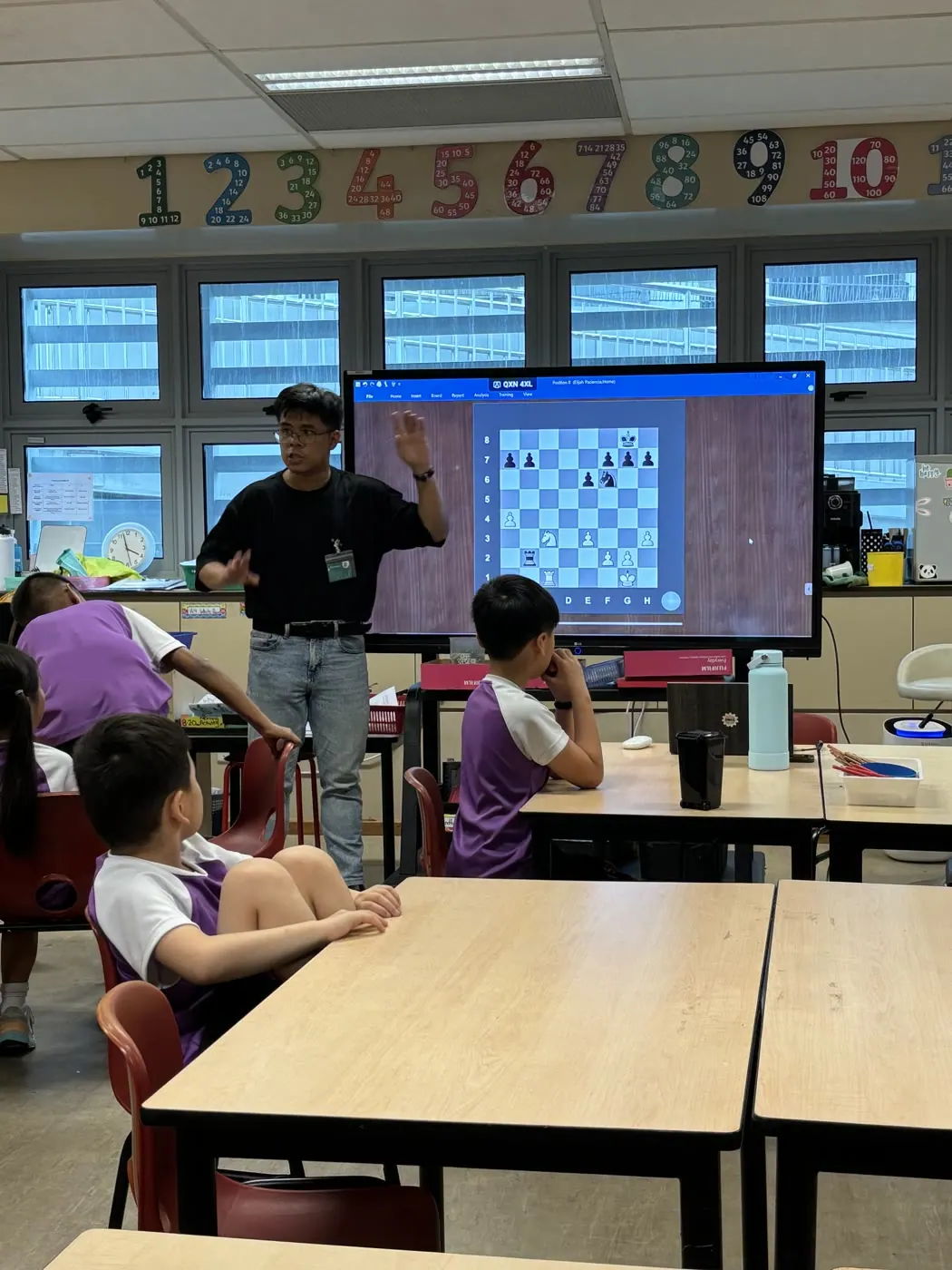 A Chess Grande coach explaining a digital chess position to Canadian International School students
