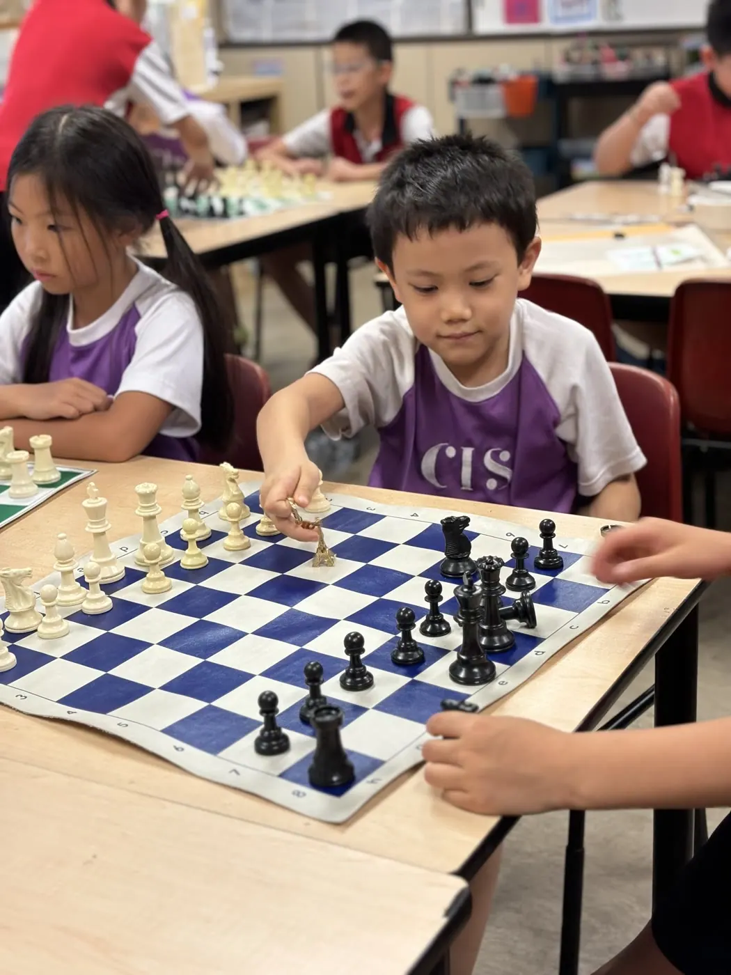 A CIS student making a move while classmates play in the background