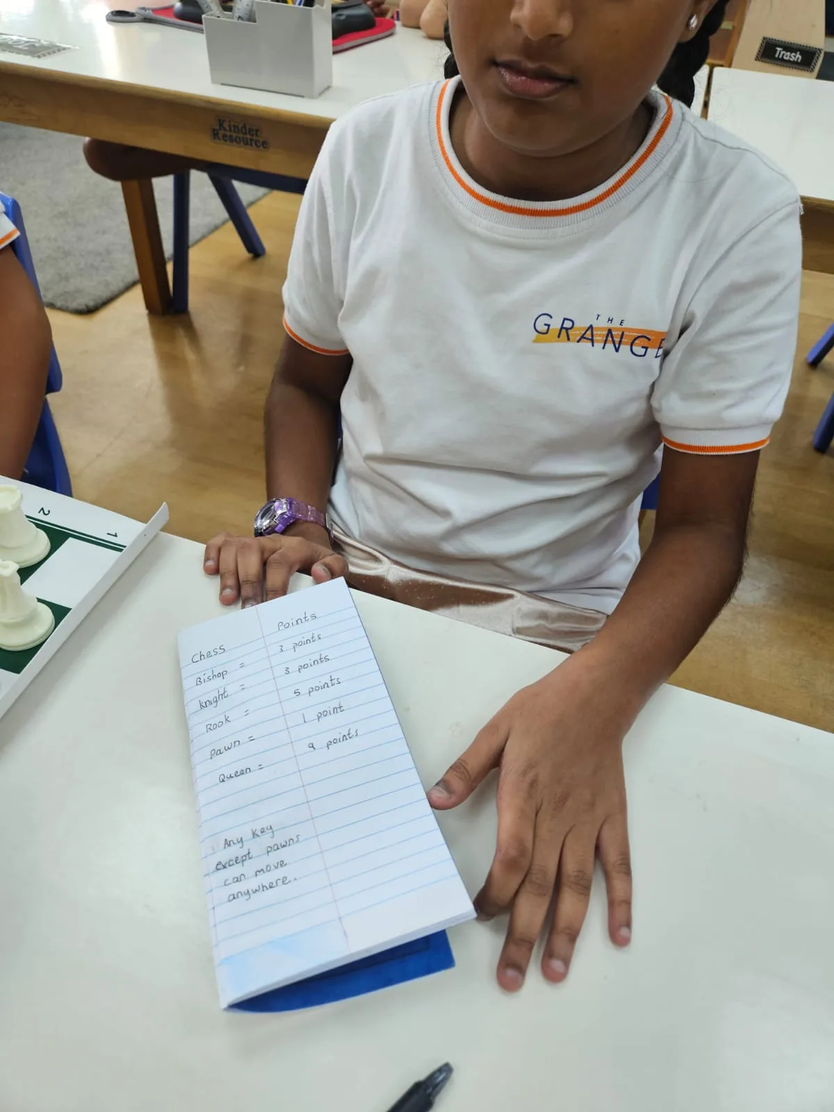 A student connecting chess pieces with their values during an academic integration lesson