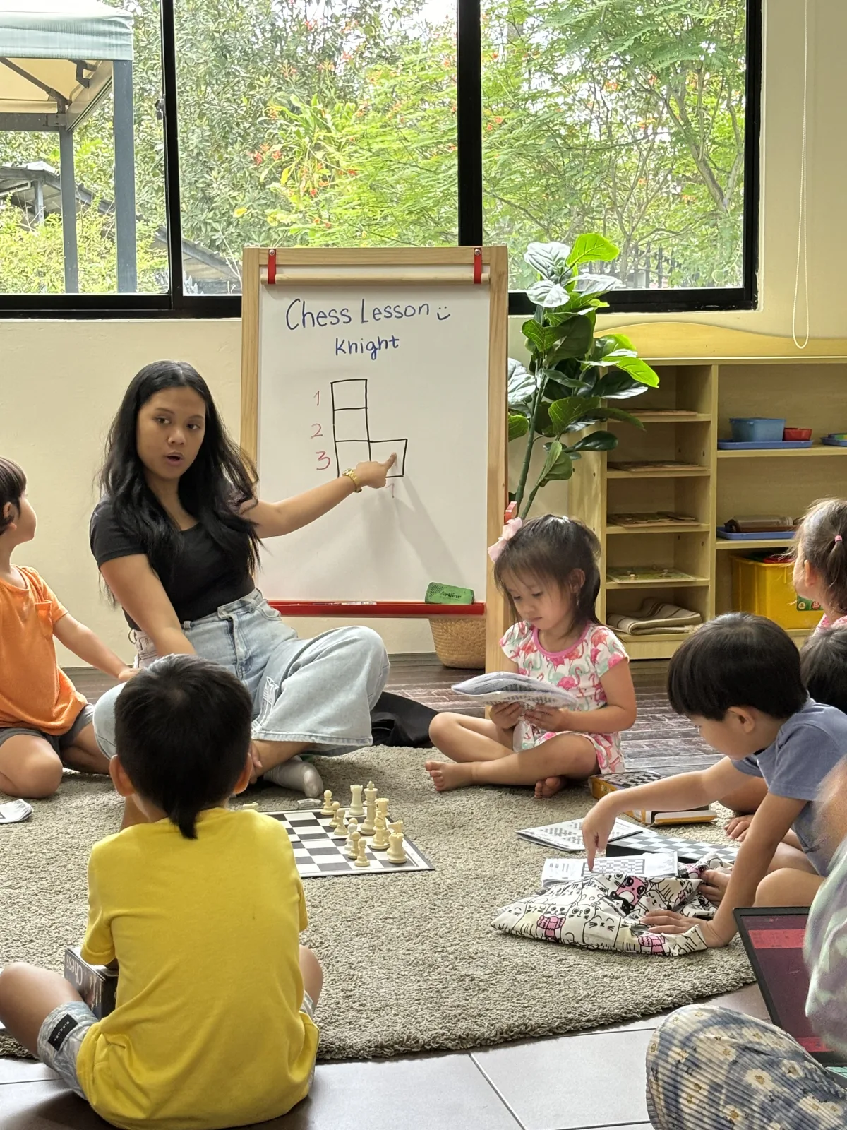 A teacher introducing chess to children at Shaws Preschool
