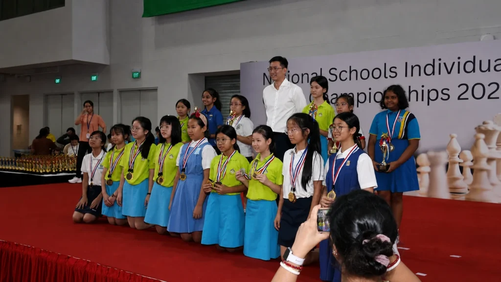 School chess players gather on stage during an awards presentation.