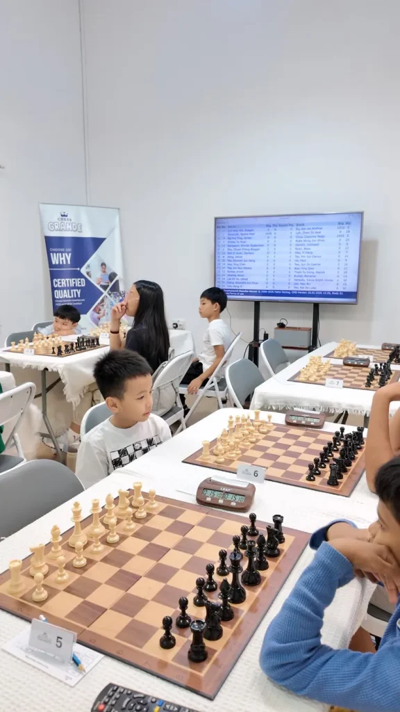 Players seated across several boards during the 7th Chess Grande Friendlies.